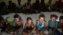 Pengungsi Rohingya menunggu di pusat penampungan sementara bekas kantor Imigrasi Punteuet di Lhokseumawe, Aceh Utara (26/6/2020). Dari hasil tes tersebut, mereka semua dinyatakan non reaktif. (AFP Photo/CHAIDEER MAHYUDDIN)