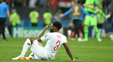 Bek timnas Inggris, Danny Rose terlihat kecewa sambil duduk di lapangan seusai babak semifinal Piala Dunia 2018 melawan Kroasia di Stadion Luzhniki, Rabu (11/7). Rose menyita perhatian lantaran mengenakan kaus kaki yang berlubang. (AFP/Kirill KUDRYAVTSEV)