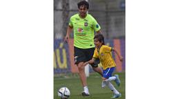 Kaka bersama putranya Luca berlatih bersama disela-sela pemusatan latihan jelang laga penyisihan Piala Dunia 2018 di Sao Paulo, Brasil, Selasa (10/11/2015). (AFP Photo/Nelson Almeida)