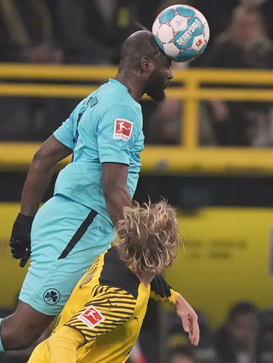Penyerang Greuther Fuerth Havard Nielsen melompati gelandang Borussia Dortmund Julian Brandt untuk menyundul bola pada laga pekan ke-16 Bundesliga di Signal Iduna Park, Kamis (16/12/2021) dini hari WIB. Borussia Dortmund mampu meraih kemenangan 3-0 atas Greuther Fuerth. (AP Photo/Martin Meissner)