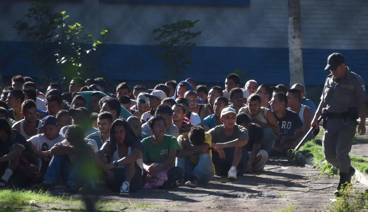 Sekelompok narapidana terlihat di sebuah penjara dengan keamanan maksimum di Guatemala, Senin (30/11). 16 tahanan tewas dalam perkelahian antarnapi di penjara tersebut. Sementara keluarga menunggu dengan cemas di luar penjara. (AFP Photo/JOHAN ORDONEZ)