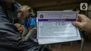 Petugas memberikan kartu vaksin rabies kepada pemilik monyet di kantor kelurahan Petukangan Selatan, Jakarta, Rabu (15/9/2021). Dinas Ketahanan Pangan dan Pertanian memberikan vaksinasi rabies bagi hewan peliharaan milik warga untuk mengantisipasi penyakit rabies. (Liputan6.com/Faizal Fanani)