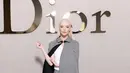 Anya-Taylor Joy tampil estetik dengan atasan putih berlapis cape kotak-kotak yang serasi dengan rok [Dior]
