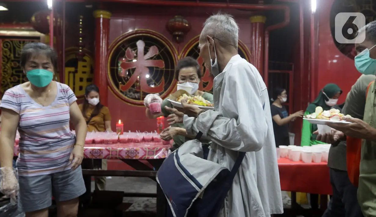 Warga menerima makanan berbuka puasa di Vihara Dharma Bhakti, Petak Sembilan, Jakarta, Kamis (7/4/2022). Yayasan Vihara Dharma Bhakti menyediakan sekitar 200 porsi menu berbuka puasa bagi warga sekitar untuk lebih mempererat persaudaraan umat beragama. (Liputan6.com/Helmi Fithriansyah)