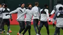 Gelandang Liverpool Mohamed Salah (tengah) bercanda dengan rekan setimnya saat sesi latihan jelang menghadapi Bayern Munchen dalam leg kedua babak 16 besar Liga Champions di Melwood, Liverpool, Inggris, Selasa (12/3). (Paul ELLIS/AFP)