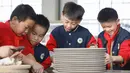 Sejumlah siswa sekolah dasar mencoba membuat porselen di bengkel kerja porselen Ru di Baofeng, Provinsi Henan, China, 15 November 2020. Baofeng dikenal sebagai produsen porselen Ru, satu dari lima porselen yang tersohor selama era Dinasti Song (960-1279) pada zaman China kuno. (Xinhua/He Wuchang)