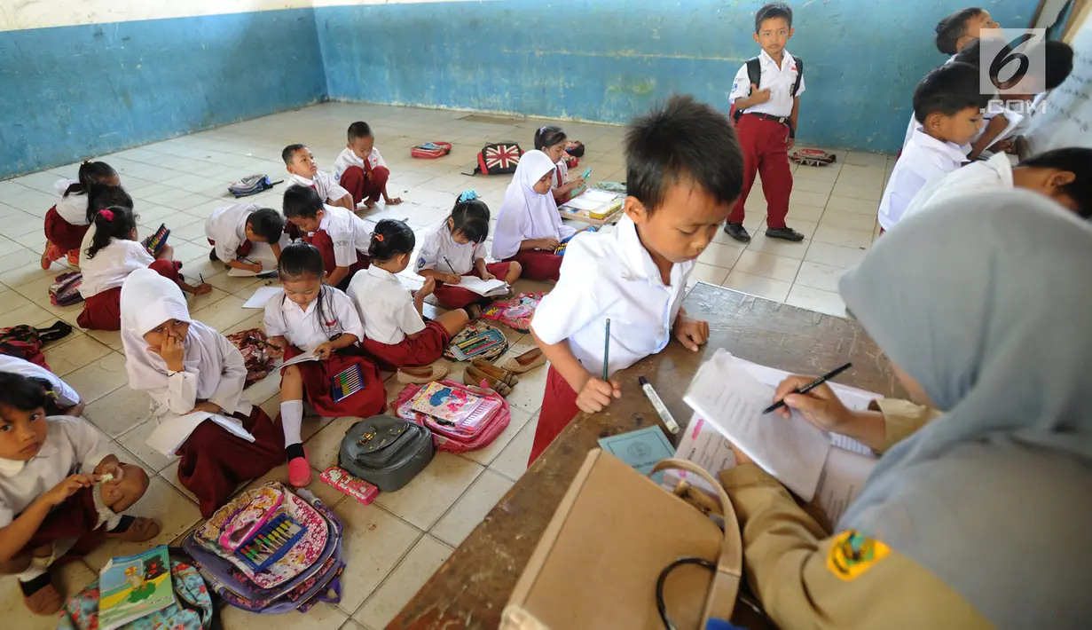 Sejumlah murid kelas II melakukan kegiatan belajar di lantai kelas SDN Kertajaya 2, Rumpin, Bogor, Senin (3/9). Tidak tersedianya meja dan kursi di tiga ruang kelas menyebabkan mereka belajar di lantai selama lebih dari 3 tahun. (Merdeka.com/Arie Basuki)