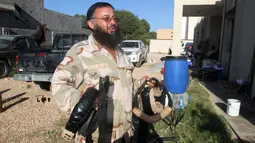 Anggota militer Libya membawa bom rakitan milik militan ISIS yang ditemukan di Sirte (5/9). Bom rakitan milik militan ISIS ini memiliki komponen kabel yang sulit untuk dijinakkan. (REUTERS/Hani Amara)
