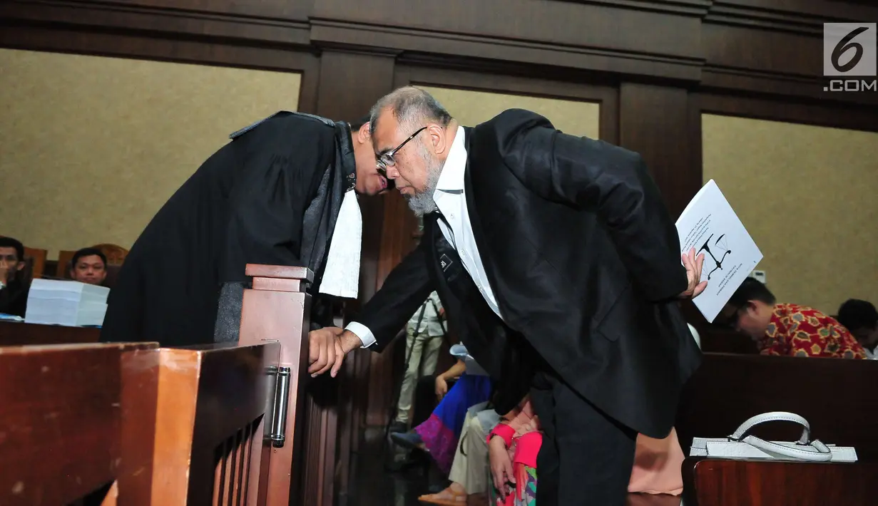 Patrialis Akbar berinteraksi dengan kuasa hukumnya saat sidang di Gedung Pengadilan Tipikor, Jakarta, Senin (21/8). Pada sidang tersebut Patrialis Akbar Membacakan Nota pembelaan sebanyak 38 halaman yang di buatnya sendiri. (Liputan6.com/Helmi Afandi)