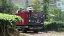 Sejumlah siswa menumpang truk di kawasan Cikoneng, Bogor, Selasa (30/3/2021). Untuk menuju sekolahnya di SDN Cikoneng, sebagian siswa harus menumpang truk, jalan kaki dan membawa kendaraan pribadi karena akses jalan yang sulit di daerah perbukitan perkebunan teh. (Liputan6.com/Herman Zakharia)