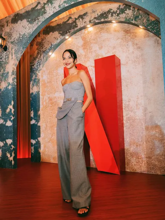 Putri Marino tampil menawan dengan outfit berwarna abu-abu. Atasan cropped tanpa tali dipadunya dengan wide-leg trouser bernuansa senada. [Foto: Instagram/putrimarino]