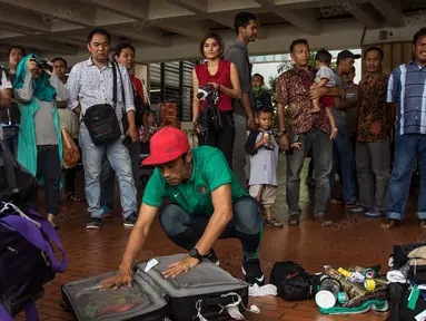 Bek kiri Timnas Indonesia, Benny Wahyudi, membongkar tas saat tiba di Bandara Soekarno-Hatta, Banten, Sabtu (26/11/2016). Pemain Arema Cronus ini kembali ke tanah air usai berlaga pada Piala AFF 2016. (Bola.com/Vitalis Yogi Trisna)