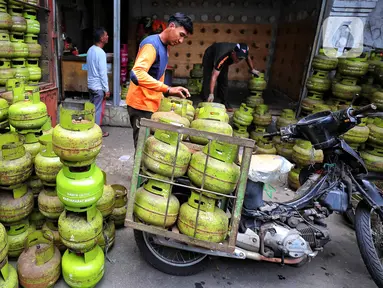 Pekerja menata tabung gas elpiji 3 kg ke atas sepeda motor untuk didistribusikan di kawasan Jakarta, Rabu (4/1/2023). Tahun 2023, pembelian elpiji 3 kg akan diperketat dengan menggunakan KTP. (Liputan6.com/Angga Yuniar)