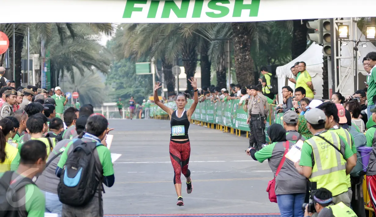 Seorang peserta wanita berhasil mencapai garis finis lomba lari 'Milo Jakarta International 10K' di kawasan Kuningan, Jakarta, Minggu (24/7). Lomba lari itu digelar untuk memperingati hari ulang tahun DKI Jakarta ke-489. (Liputan6.com/Yoppy Renato)