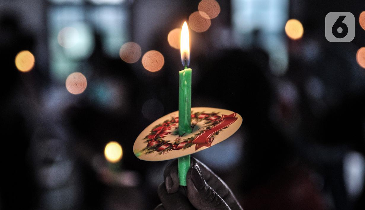Jemaat HKBP Filadelfia menyalakan lilin saat ibadah malam Natal di Gedung Serbaguna Mandiri Sejahtra CBL, Desa Sumber Jaya, Tambun, Bekasi, Jawa Barat, Kamis (24/12/2020). Keterbatasan dan pandemi COVID-19 tak menyurutkan niat ibadah jemaat HKBP Filadelfia. (merdeka.com/Iqbal S. Nugroho)
