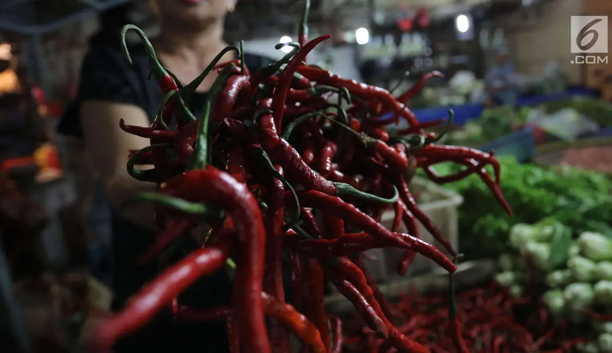 Pedagang menunjukkan cabai merah di pasar di Jakarta, Rabu (20/12).  Jelang Natal dan Tahun Baru, harga bahan pokok di Jakarta mulai merangkak naik. Namun, kenaikannya masih belum tinggi hanya berkisar Rp2.000-5.000 per kg. (Liputan6.com/Angga Yuniar)