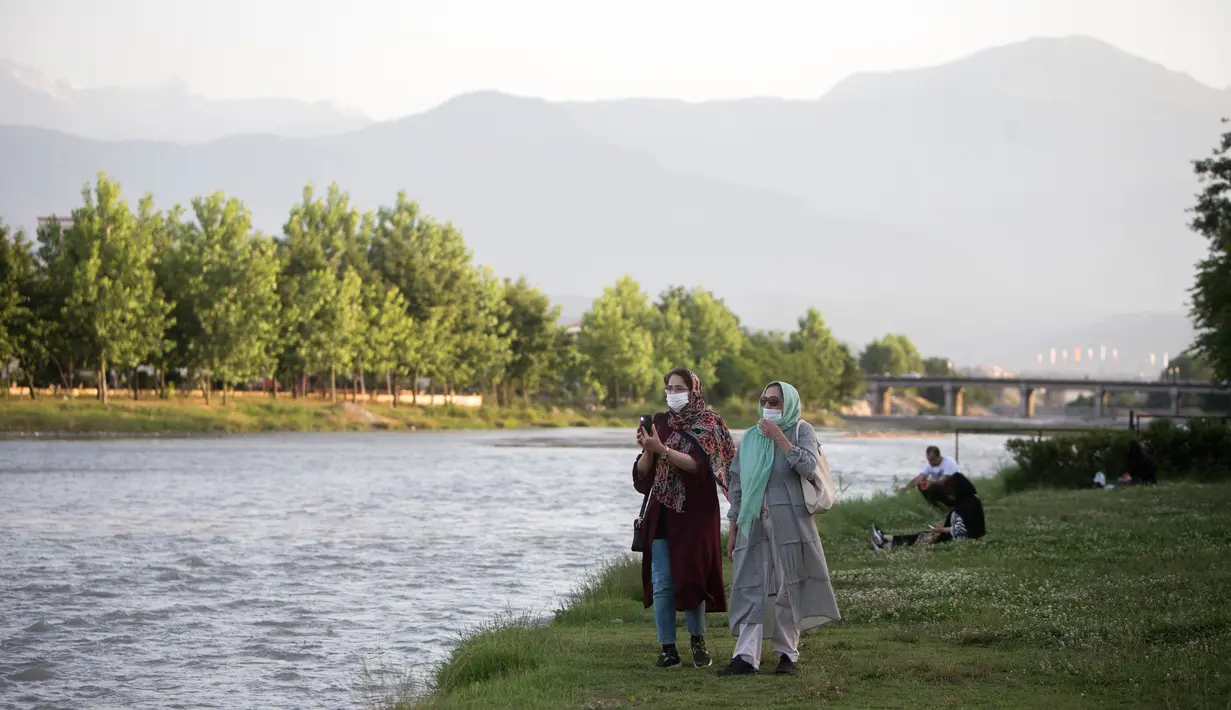 Para wanita yang mengenakan masker berjalan di tepi sungai di Kota Tonekabon, Iran utara (16/6/2020). Iran pada Rabu (17/6) melaporkan 2.612 kasus baru COVID-19, menambah total kasus terkonfirmasi di negara itu menjadi 195.051, demikian dilaporkan kantor berita resmi IRNA. (Xinhua/Ahmad Halabisaz)
