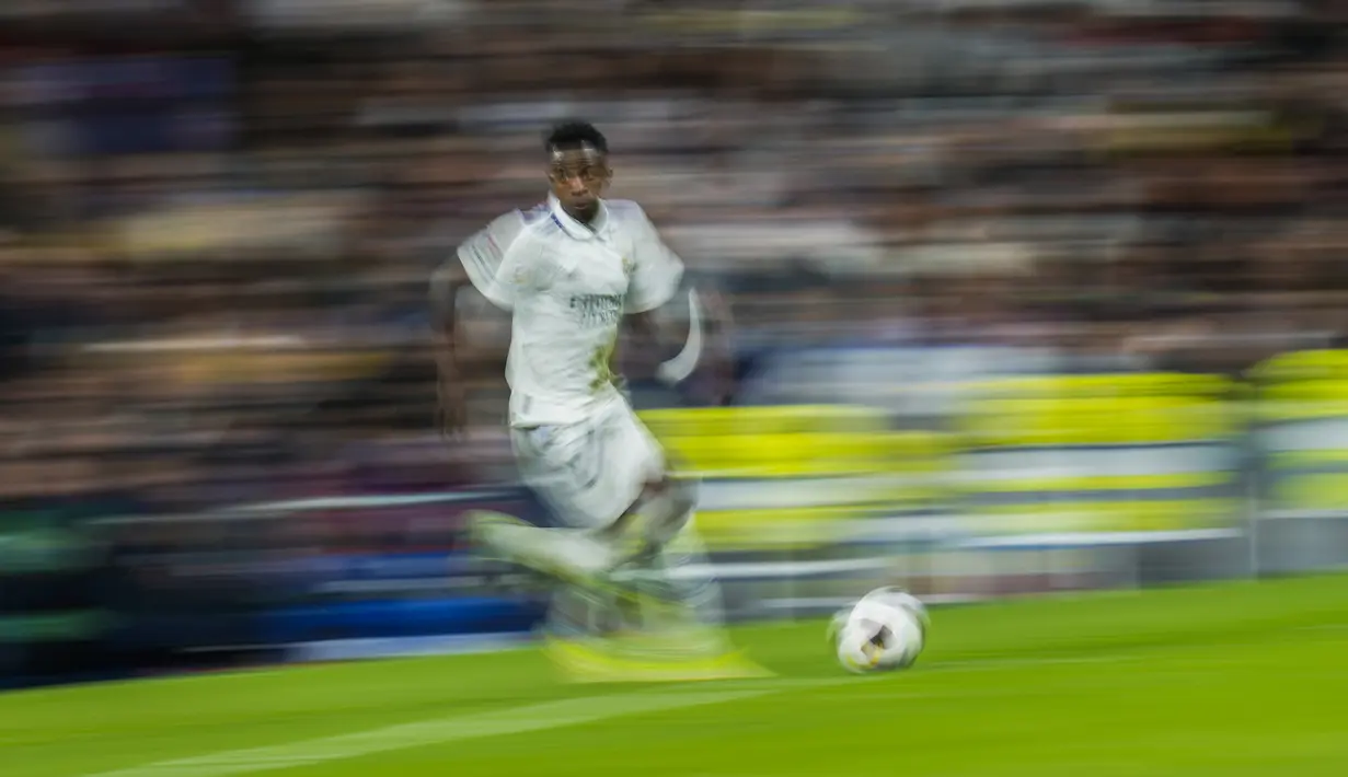 Penyerang Real Madrid, Vinicius Junior berlari membawa bola saat bertanding melawan Cadiz selama pertandingan lanjutan La Liga Spanyol di stadion Santiago Bernabeu di Madrid, Jumat (11/11/2022). Tambahan tiga poin ini membuat Madrid terus menempel Barcelona di puncak klasemen La Liga. (AP Photo/Manu Fernandez)