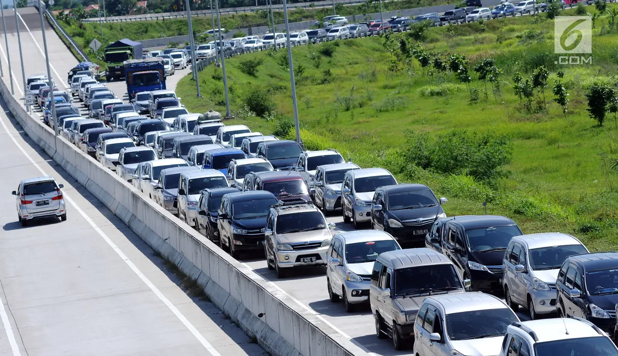 Sejumlah kendaraan antre menuju pintu keluar Tol Brebes Barat, Jawa Tengah, Sabtu (23/12). Untuk mengurangi kemacetan di pintu Tol Brebes Timur petugas mengalihkan arus lalu lintas keluar Tol Brebes Barat. (Liputan6.com/Helmi Fithriansyah)