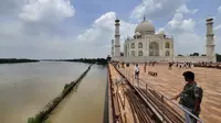 Pada hari Rabu, dinding pembatas batu pasir merah Taj Mahal dikelilingi oleh air berlumpur berwarna coklat, bahkan ketika sekumpulan turis memadati monumen bersejarah yang tidak tersentuh oleh sungai. (AP Photo/Aryan Kaushik)