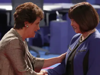 Anne Holton berjabat tangan dengan Karen Pence menjelang dimulainya debat cawapres AS di Longwood University, Virginia, Selasa (4/10). Debat yang mempertemukan dua cawapres AS, Tim Kaine dan Mike Pence berlangsung cukup tegang. (AFP/Mark Wilson)