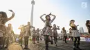 Aksi para personel girlband JKT48 saat tampil dalam puncak Kirab Obor Asian Games 2018 di Monas, Jakarta, Sabtu (18/8). Obor Asian Games 2018 diarak dari Monumen Nasional (Monas) menuju Stadion Utama Gelora Bung Karno (SUGBK). (Liputan6.com/Faizal Fanani)