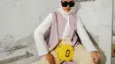 Influencer Ana Octarina mengenakan outer lilac yang dipadu dengan blouse dan hijab putih. Untuk bawahan, ia memilih soft yellow pants. (Instagram/anaoctarina).