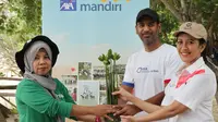 Direktur PT AXA Mandiri Financial Services (AXA Mandiri) Aayush Poddar (tengah), dan Chief Communication Officer AXA Mandiri, Atria Rai (kanan) menyerahkan secara simbolis bibit pohon bakau kepada penggiat Kelompok Tani Hutan dan Nelayan Pulau Pari, Asmania di Pulau Pari, Kepulauan Seribu, Jakarta (22/6/2023). (Liputan6.com/HO)