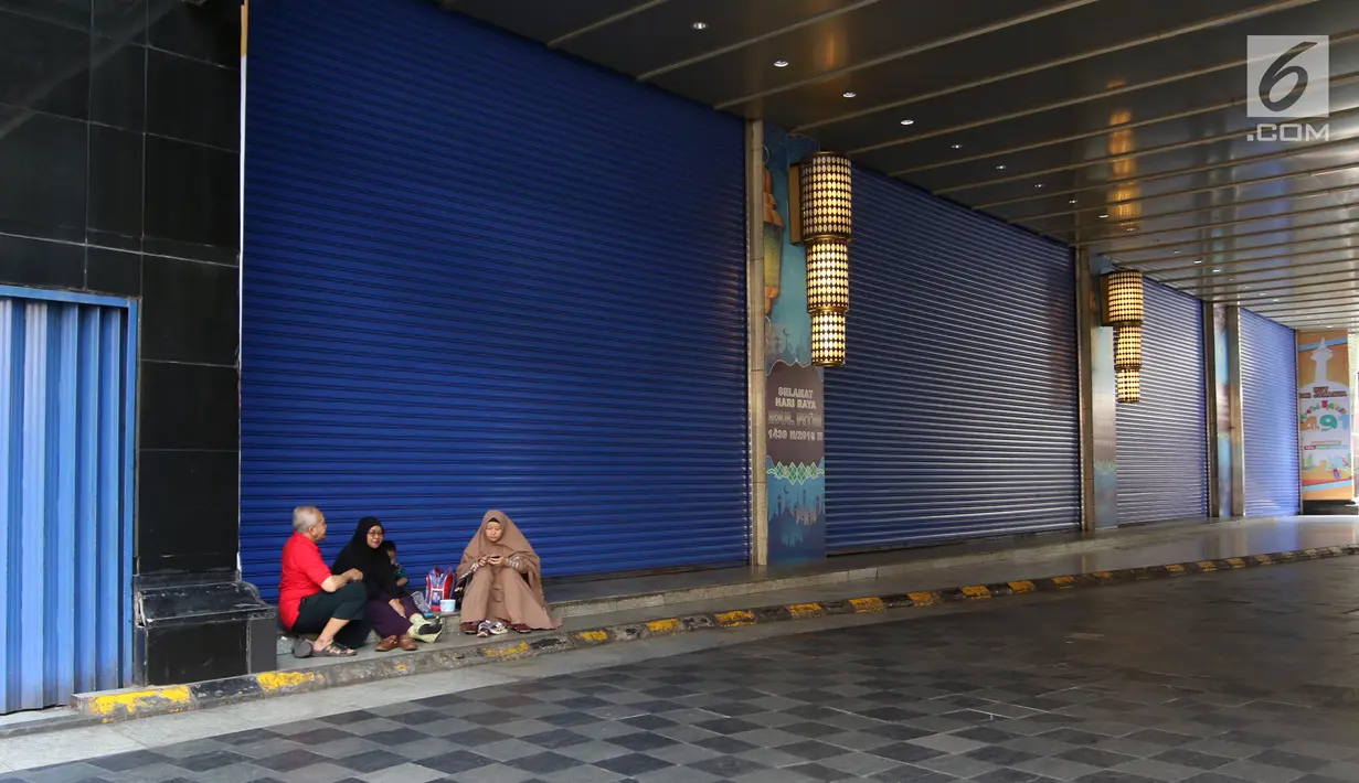 Warga beristirahat di Gedung Blok B Pasar Tanah Abang, Jakarta, Minggu (17/6). Dalam rangka menyambut Hari Raya Idul Fitri 1439 H, Pasar Tanah Abang tutup selama 10 hari. (Liputan6.com/Arya Manggala)