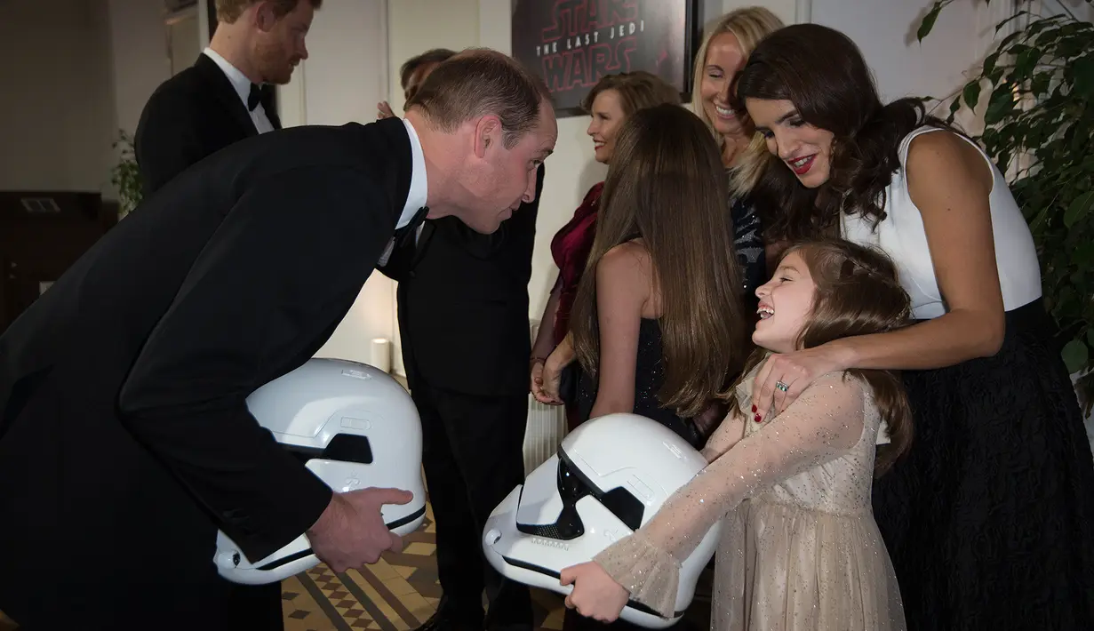 Pangeran William diberi helm karakter Stormtroopers saat premiere film Star Wars: The Last Jedi di The Royal Albert Hall, London, Selasa (12/12). Dalam film itu, William dan Pangeran Harry menjadi cameo sebagai Stormtroopers. (Vianney Le Caer/Invision/AP)