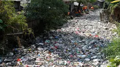 Petugas kebersihan membersihkan sampah di Kali Bahagia, Bekasi, Jawa Barat, Kamis (1/8/2019). Sampah di Kali Bahagia semakin menumpuk hingga menyerupai daratan. (AP Photo/Tatan Syuflana)