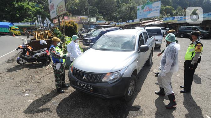 Petugas memeriksa kendaraan saat penyekatan arus lalu lintas di kawasan Ciloto, Cianjur, Jawa Barat, Jumat (17/4/2020). Pemkab Cianjur melakukan pengecekan suhu tubuh dan penyemprotan disinfektan di sejumlah titik keluar-masuk Cianjur untuk mencegah penyebaran COVID-19. (merdeka.com/Arie Basuki)
