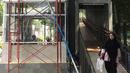 Pejalan kaki melintas di dekat pembangunan lift pada jembatan penyeberangan orang di Jakarta, Senin (13/5). Pembangunan lift pada tiga JPO yang berada di Jalan Sudirman itu bertujuan meningkatkan kenyamanan kepada warga dan ditargetkan rampung akhir bulan ini.(Liputan6.com/Immanuel Antonius)