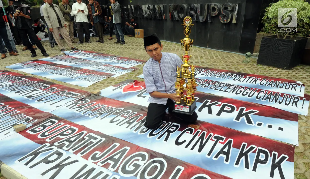 Tokoh masyarakat Kabupaten Cianjur berpose dengan sebuah piala di Gedung KPK, Jakarta, Selasa (18/12). Piala itu diberikan sebagai apresiasi atas operasi tangkap tangan (OTT) Bupati Cianjur Irvan Rivano Muchtar oleh KPK. (Merdeka.com/Dwi Narwoko)