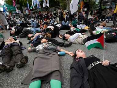 Sejumlah warga yang menyatakan solidaritas terhadap Palestina berbaring di jalan saat mengikuti aksi yang mengecam tindakan militer Amerika Serikat dan Israel di Gaza, di Seoul, Korea Selatan, Sabtu (3/10/2026). Aksi die-in tersebut dilakukan sebagai simbol untuk menggambarkan korban konflik di Gaza. Para peserta berkumpul dan menyampaikan dukungan terhadap Palestina dalam unjuk rasa yang berlangsung di kawasan pusat Kota Seoul. (AP Photo/Ahn Young-joon)