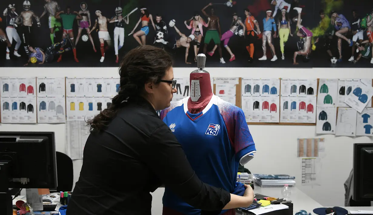 Pekerja memakaikan seragam timnas sepak bola Islandia rancangan Errea pada maneken di Torrile, dekat Parma, Italia Utara, (20/4). Seragam timnas Islandia ini merupakan rancangan perusahaan apparel olahraga asal Italia. (AFP Photo/Marco Bertorello)