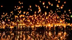 Sejumlah orang melepaskan lampion ke udara saat mereka merayakan festival Yee Peng di Chiang Mai (3/11). Dalam festival ini, ratusan bahkan ribuan orang beramai-ramai menerbangkan lampion ke udara. (AFP Photo/Roberto Schmidt)
