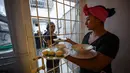 Dua narapidana wanita menyiapkan makanan saat bekerja di restoran Interno di Cartagena, Kolombia (24/8). Dengan adanya restoran ini narapidana wanita menerima pelatihan agar setelah bebas bisa diterima kembali oleh masyarakat. (AFP Photo/Raul Arboleda)