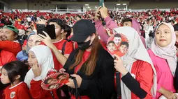 Suporter wanita menunggu pemain Timnas Indonesia yang berkeliling lapangan setelah menghadapi Irak pada laga Grup F putaran kedua Kualifikasi Piala Dunia 2026 zona Asia di Stadion Utama Gelora Bung Karno (SUGBK), Senayan, Jakarta, Kamis (6/6/2024). (Bola.com/M Iqbal Ichsan)