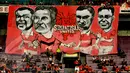 Simpatisan United membentangkan spanduk bergambar karikatur para legenda pemain Manchester United (Liputan 6.com/Helmi Fithriansyah).