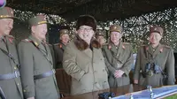 Pemimpin Korea Utara Kim Jong Un (tengah) tersenyum dengan para perwira militer lainnya saat mengamati latihan militer di Korea Utara, Jumat (25/3). Lokasi berlangsungnya latihan militer ini pun masih tidak diketahui kejelasannya. (Reuters/KCNA)