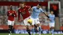 Bek Manchester United, Luke Shaw (kiri), berebut bola dengan striker Manchester City, Riyad Mahrez, dalam laga lanjutan Liga Inggris 2020/21 pekan ke-12 di Old Trafford Stadium, Sabtu (12/12/2020). Manchester United bermain imbang 0-0 dengan Manchester City. (AFP/Phil Noble/Pool)