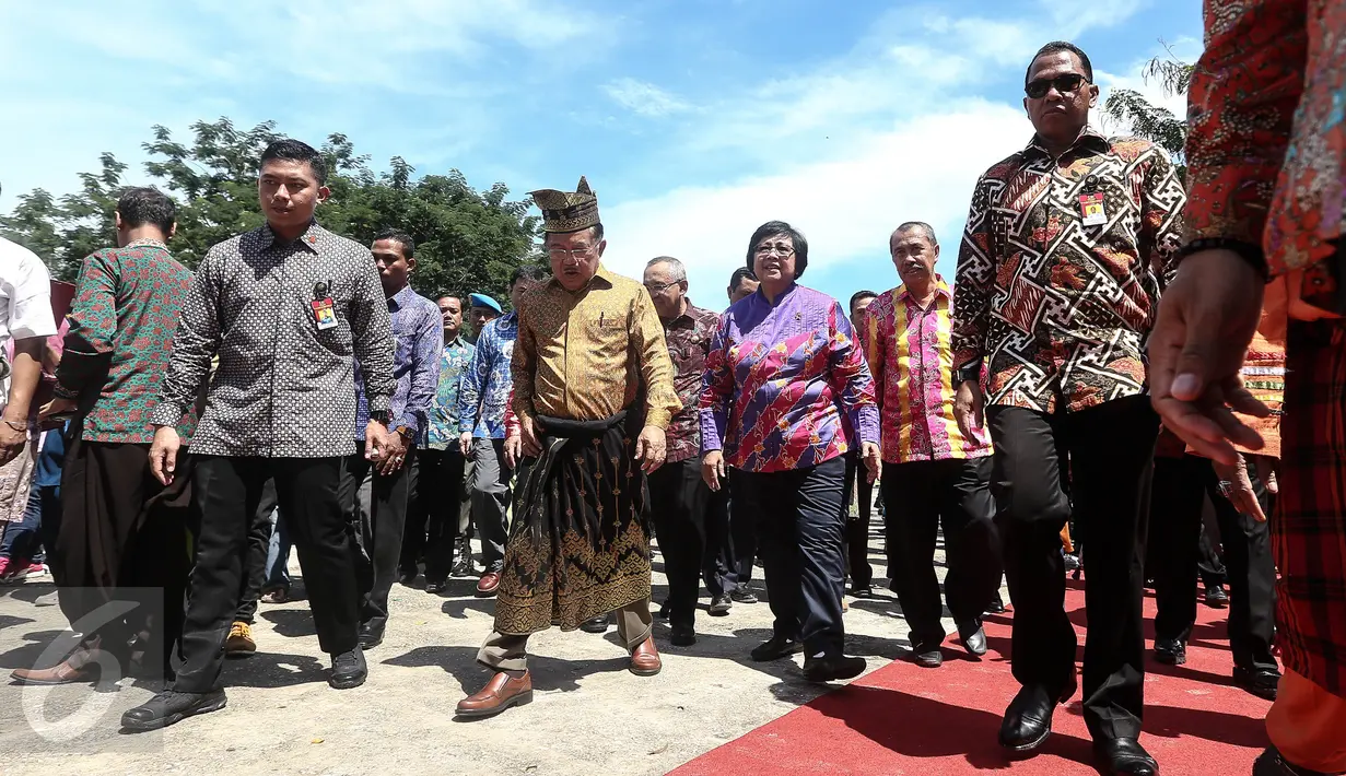 Wapres Jusuf Kalla didampingi Menteri LHK, Siti Nurbaya bersiap menanam pohon disamping Istana Siak Sri Indrapura seusai menghadiri puncak Hari Lingkungan Hidup 2016 di Kabupaten Siak, Riau, Jumat (22/7). (Liputan6.com/Faizal Fanani)