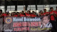 Spanduk berwajah Novel Baswedan dibawa saat sejumlah beraksi di Gedung Dwi Warna KPK, Jakarta, Senin (17/4). Mereka meminta KPK terus melindungi para penyidiknya agar mampu memberantas kasus mega korupsi e-KTP. (Liputan6.com/Helmi Afandi) 