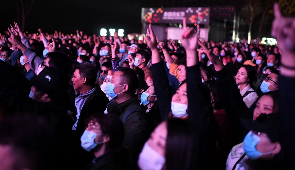 Orang-orang yang memakai masker menyaksikan penampilan sebuah band pada Festival Musik Rye yang digelar selama dua hari di Beijing pada 18 Oktober 2020. (Photo by Noel Celis / AFP)