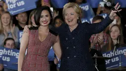 Calon presiden AS dari Partai Demokrat Hillary Clinton merangkul penyanyi Demi Lovato saat acara kampanye di Iowa City, Iowa, Amerika Serikat, (21/). Hillary menjadi satu-satunya perempuan yang mencalonkan diri menjadi Presiden AS. (REUTERS/Jim Muda)