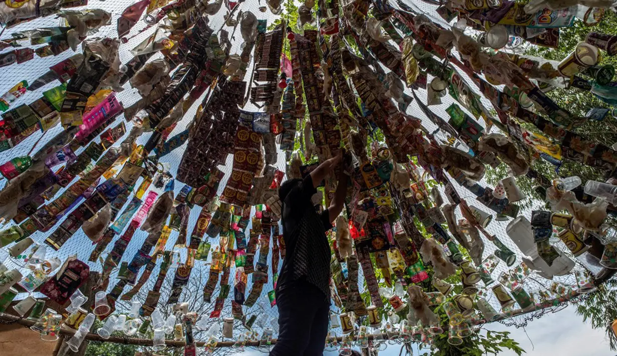 Aktivis Ecological Observation and Wetland Conservation (Ecoton) membuat instalasi yang terbuat dari sampah plastik di Gresik, Jawa Timur, 17 September 2021. Instalasi tersebut di antaranya terbuat dari 4.444 botol. (JUNI KRISWANTO/AFP)
