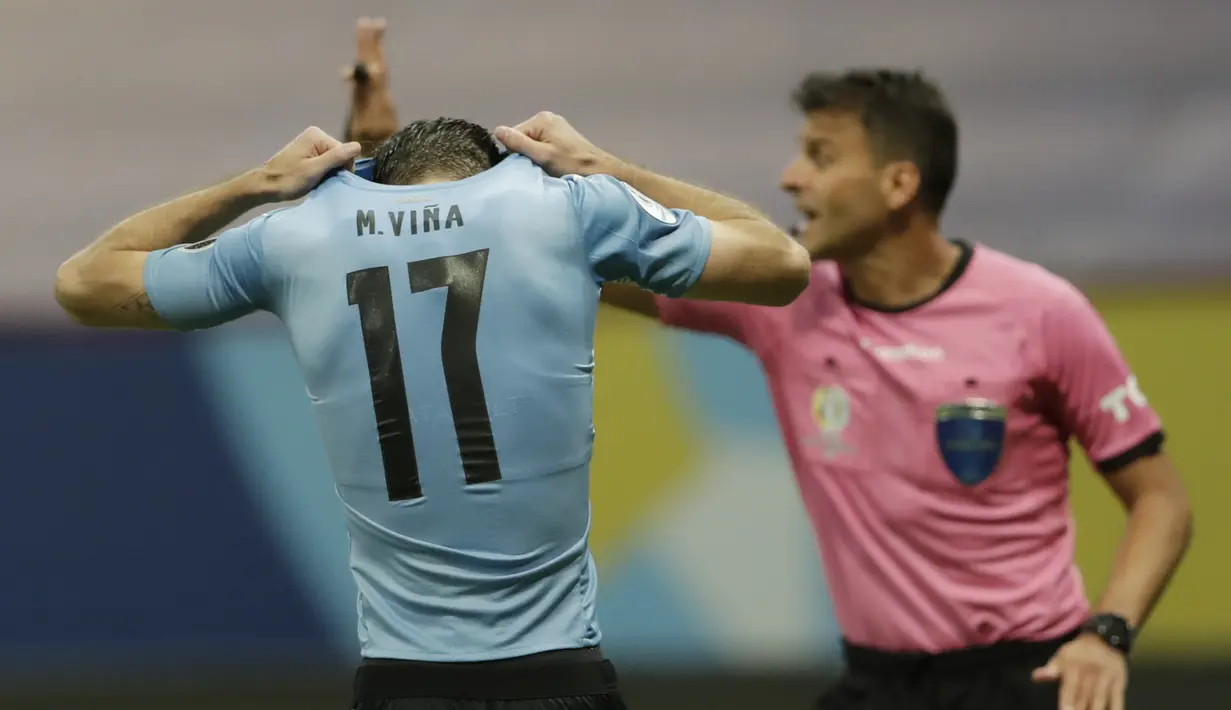 Bek timnas Uruguay, Matias Vina menutupi kepalanya setelah gagal melakukan tendangan penalti dalam laga perempat final Copa America 2021 di Stadion Nacional de Brasilia, Brasil, Minggu (4/7/2021) pagi WIB. Kolombia mengalahkan Uruguay lewat adu penalti dengan skor 4-2. (AP Photo/Silvia Izquierdo)