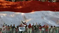 Suporter bersorak di bawah bendera Merah Putih raksasa jelang menyaksikan laga final pertama Piala AFF 2016 antara Indonesia melawan Thailand di Stadion Pakansari, Bogor, Rabu (14/12). Indonesia unggul 2-1 atas Thailand. (Liputan6.com/Helmi Fithriansyah)