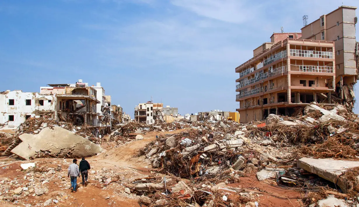 Seorang pria berjalan melewati puing-puing bangunan yang disebabkan oleh banjir bandang di Derna, Libya timur, pada 11 September 2023. Banjir bandang di Libya timur menewaskan lebih dari 2.300 orang di kota pesisir Mediterania, Derna. (AFP)